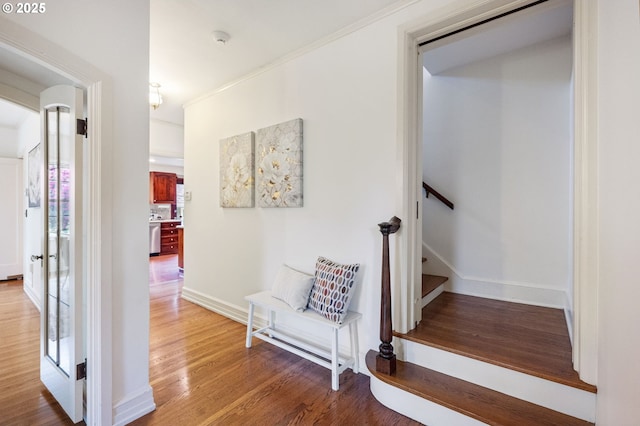 hallway featuring light wood-type flooring, stairs, and baseboards