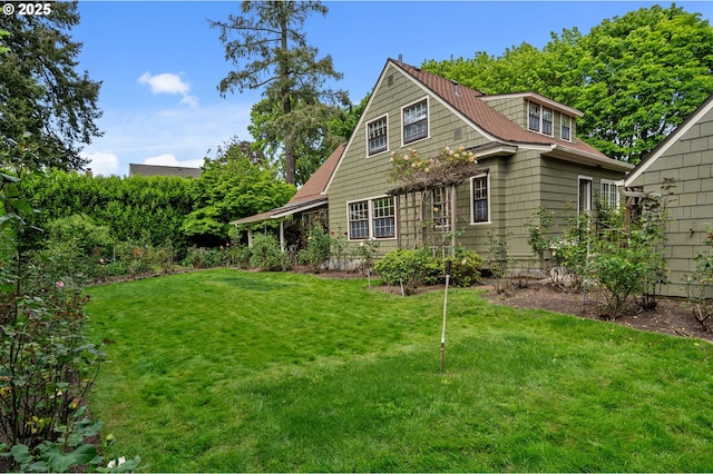 rear view of property featuring a lawn