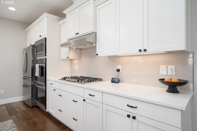 kitchen featuring white cabinetry, tasteful backsplash, dark hardwood / wood-style floors, and appliances with stainless steel finishes