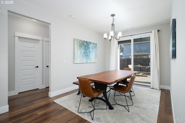 dining space featuring dark hardwood / wood-style floors and an inviting chandelier