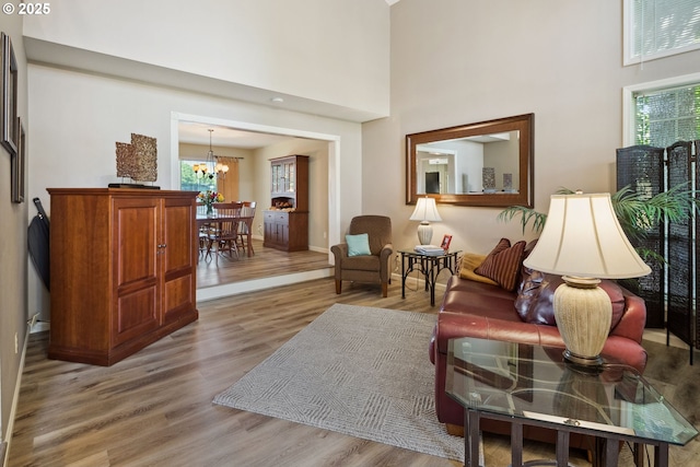 17958 Saint Clair Dr, Lake Oswego, OR 97034 - living room featuring plenty of natural light, a towering ceiling, light wood-style floors, and a chandelier