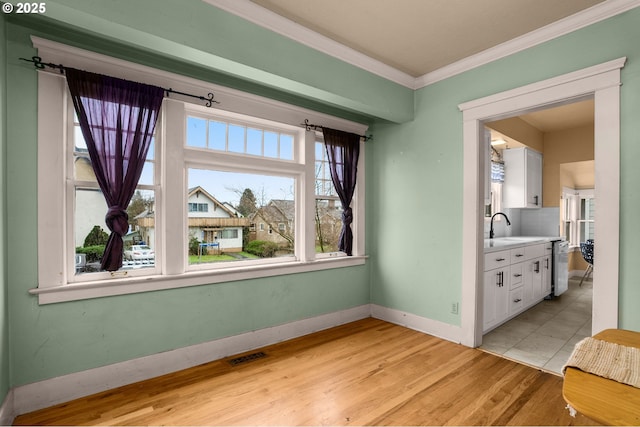 dining space with crown molding, light wood-style flooring, baseboards, and visible vents