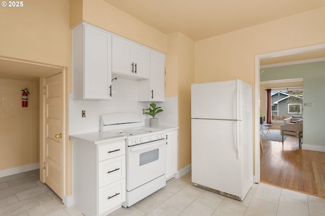 kitchen with decorative backsplash, white appliances, white cabinetry, and light countertops