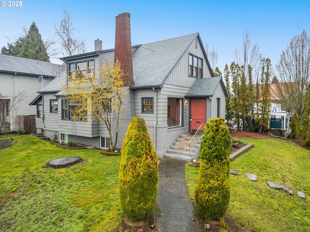 view of front facade featuring board and batten siding, a chimney, and a front yard