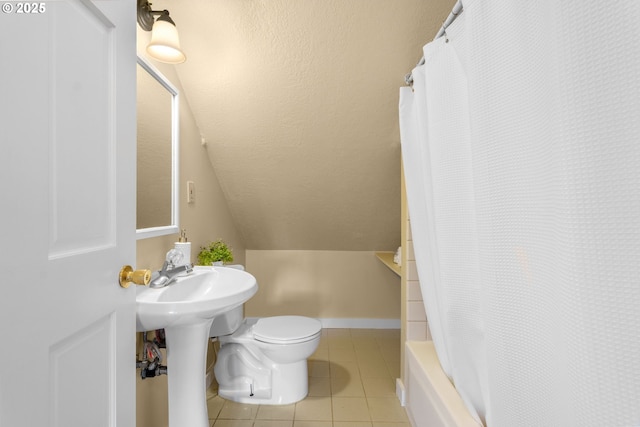 bathroom with tile patterned floors, baseboards, toilet, and lofted ceiling