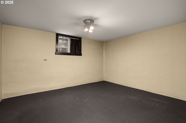 unfurnished room with concrete floors and a textured wall