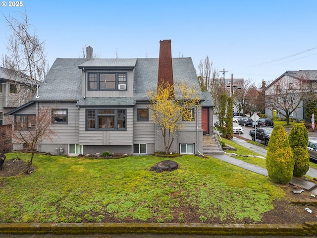 view of front of house featuring a chimney and a front lawn