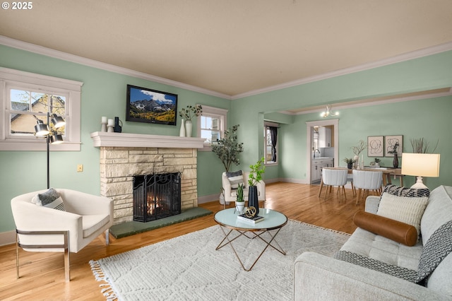 living area with a stone fireplace, plenty of natural light, and wood finished floors