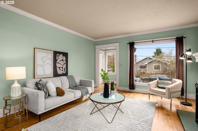 living area with crown molding, wood finished floors, and baseboards