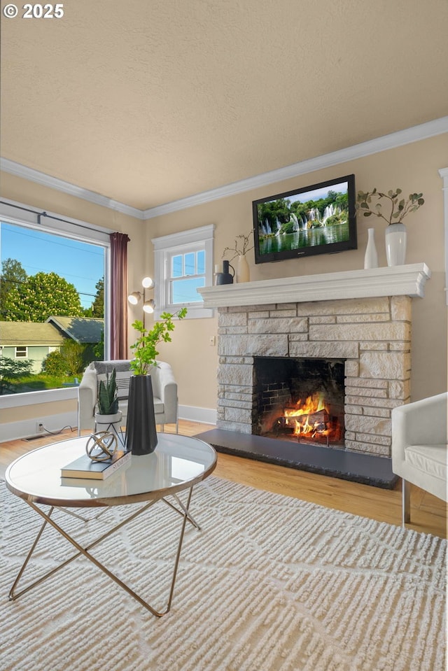 living area with crown molding, a textured ceiling, wood finished floors, and a fireplace