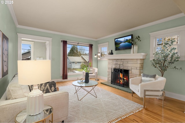 living room with a stone fireplace, wood finished floors, and a wealth of natural light