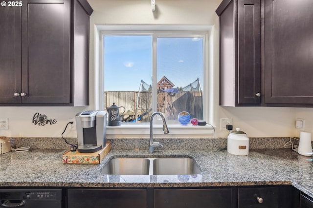 kitchen featuring light stone countertops, sink, and dark brown cabinets