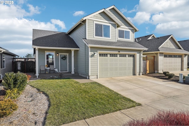 view of front of property featuring a garage, covered porch, and a front yard