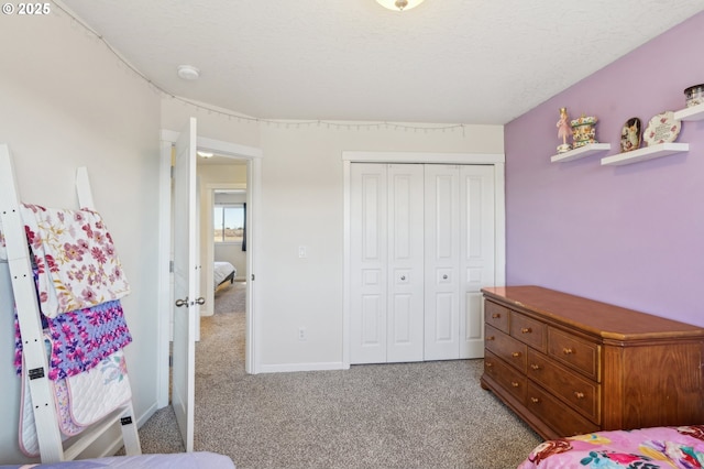 carpeted bedroom with a textured ceiling and a closet