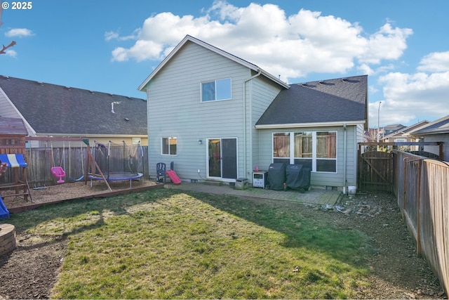 back of property featuring a playground, a trampoline, and a lawn