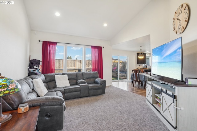 carpeted living room with high vaulted ceiling