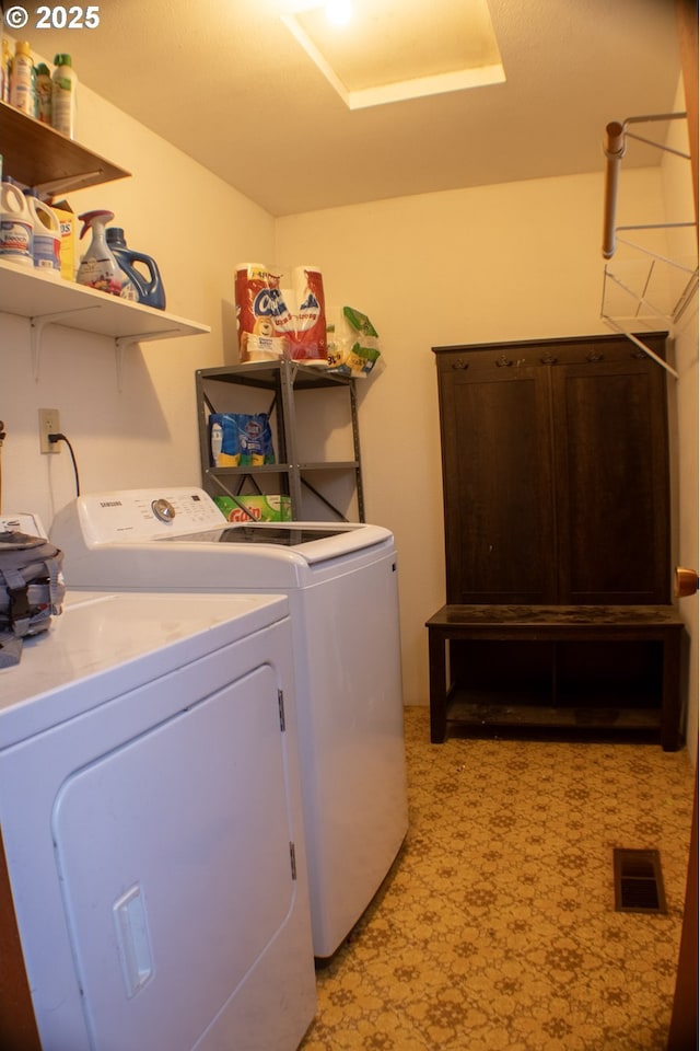 clothes washing area with washing machine and dryer