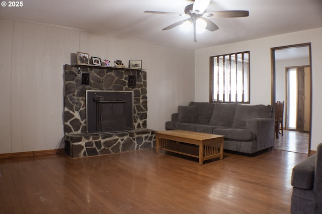 living room with hardwood / wood-style flooring, ceiling fan, and a fireplace