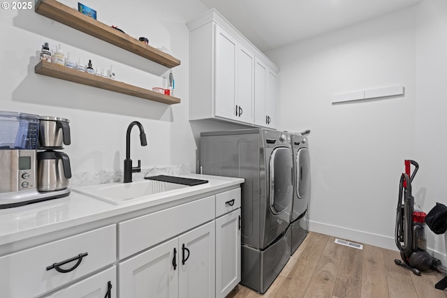 50322 Briarwood Ct, Scappoose, OR 97056 - washroom featuring separate washer and dryer, light wood finished floors, and cabinet space