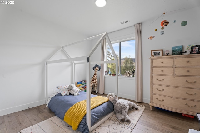 bedroom with visible vents, baseboards, and hardwood / wood-style floors