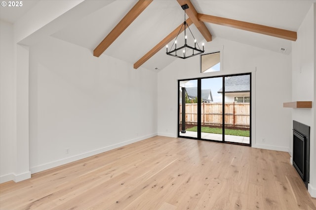 unfurnished living room featuring lofted ceiling with beams, a chandelier, and light hardwood / wood-style floors