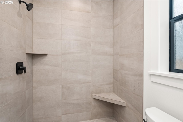 bathroom with toilet and a tile shower