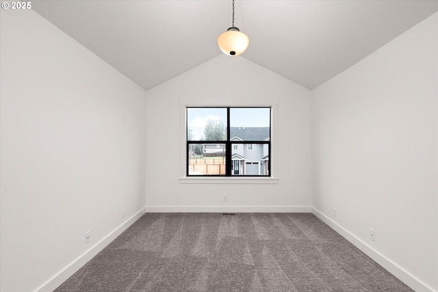 carpeted spare room featuring vaulted ceiling