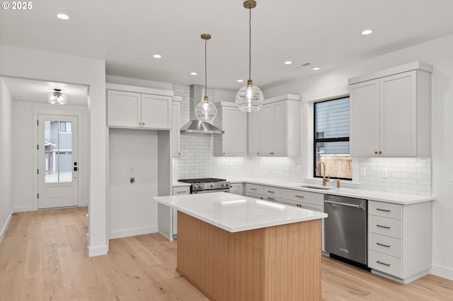 kitchen with a center island, sink, hanging light fixtures, appliances with stainless steel finishes, and white cabinets