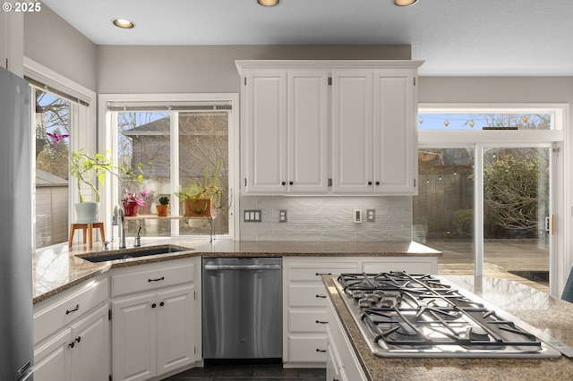 kitchen featuring sink, stainless steel appliances, white cabinets, and stone countertops