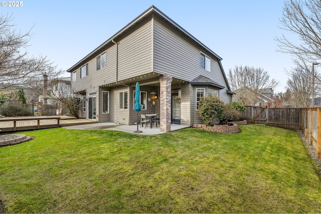 rear view of house featuring a patio, a yard, and a wooden deck