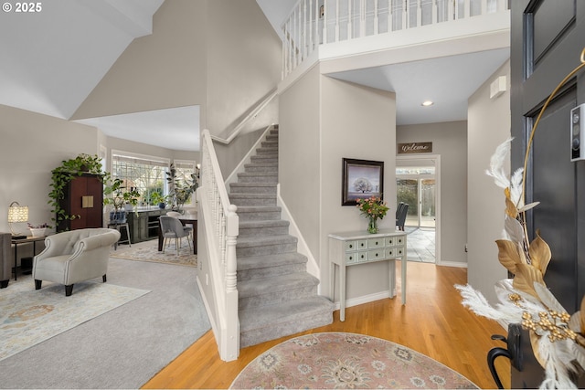 entrance foyer featuring a towering ceiling and light hardwood / wood-style flooring