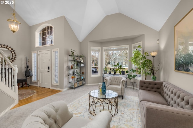 living room with vaulted ceiling, a notable chandelier, and light wood-type flooring