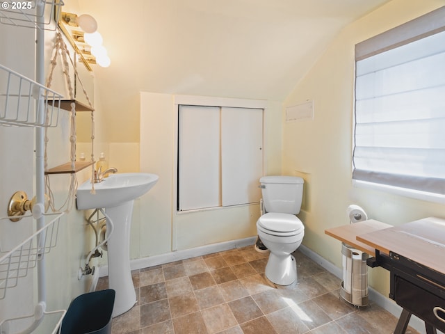 1749 NE 19th St, Lincoln City, OR 97367 - bathroom with vaulted ceiling, toilet, baseboards, stone finish floors, and a sink