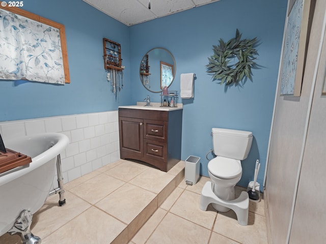 1749 NE 19th St, Lincoln City, OR 97367 - bathroom featuring a freestanding bath, vanity, toilet, tile patterned flooring, and a paneled ceiling
