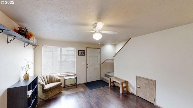 interior space featuring a textured ceiling, dark wood-type flooring, stairway, and a ceiling fan