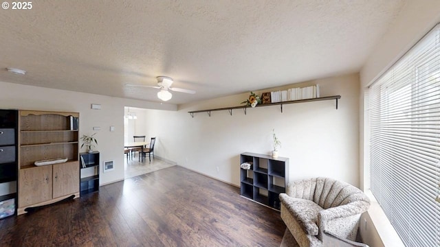 sitting room with ceiling fan, a textured ceiling, and wood finished floors