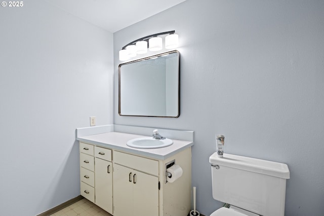 half bathroom featuring vanity, tile patterned floors, and toilet