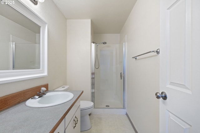 bathroom with toilet, a stall shower, and vanity