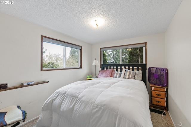 bedroom with baseboards, carpet, and a textured ceiling