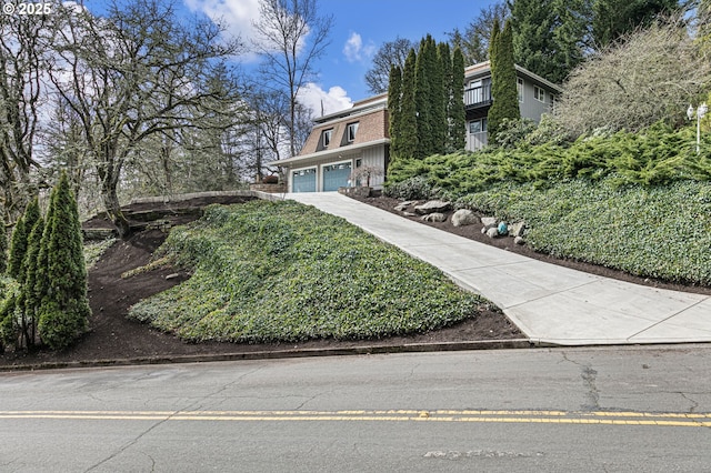 view of front of property with mansard roof, concrete driveway, and an attached garage