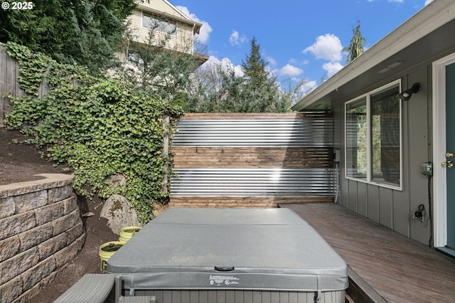 view of patio with a hot tub and fence