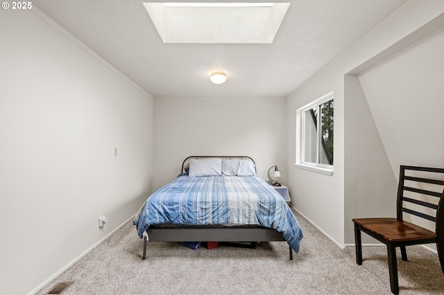 bedroom with carpet floors, a skylight, and crown molding