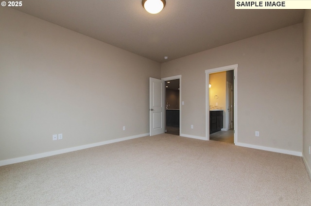 unfurnished bedroom with light colored carpet and ensuite bath