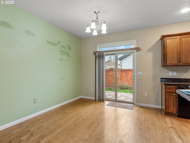 interior space featuring visible vents, baseboards, light wood-style flooring, a textured ceiling, and a chandelier