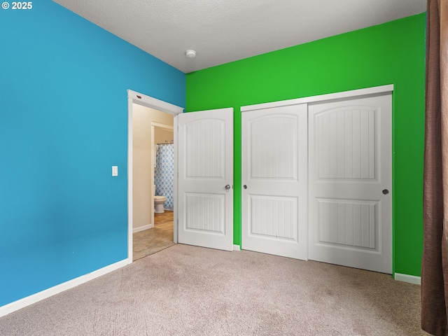 unfurnished bedroom with baseboards, a closet, and carpet floors