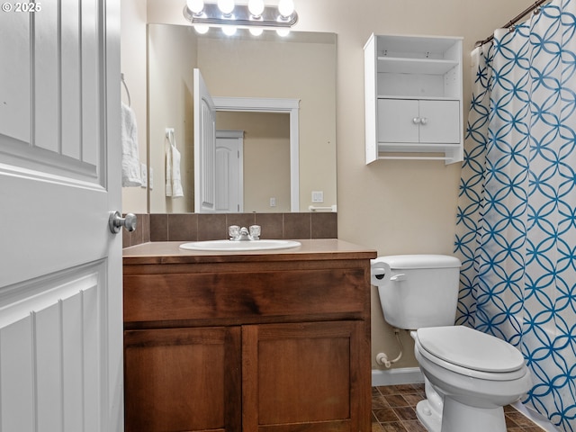 full bath featuring toilet, vanity, and a shower with curtain