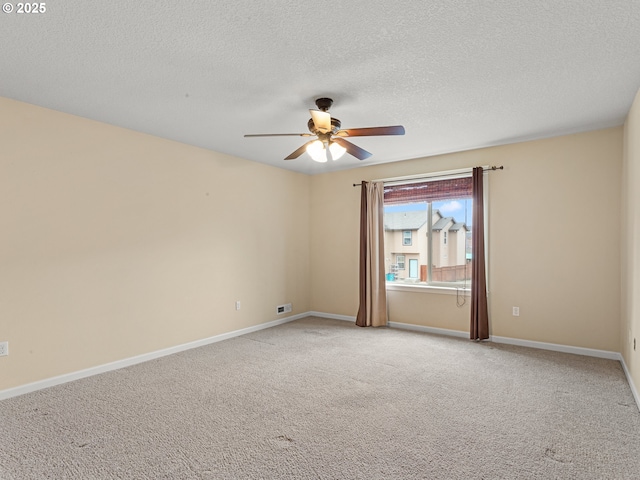 spare room featuring visible vents, baseboards, ceiling fan, light colored carpet, and a textured ceiling