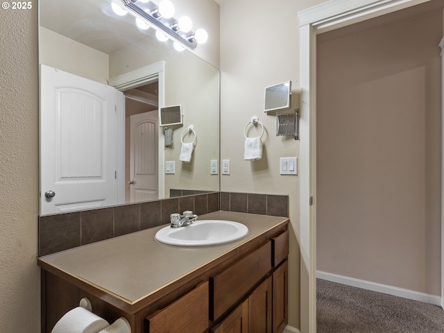 bathroom featuring baseboards, backsplash, and vanity