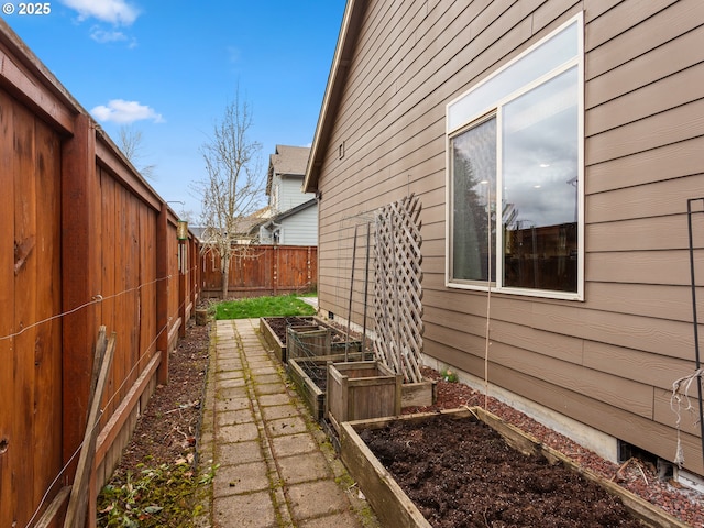 view of side of property featuring a vegetable garden and fence