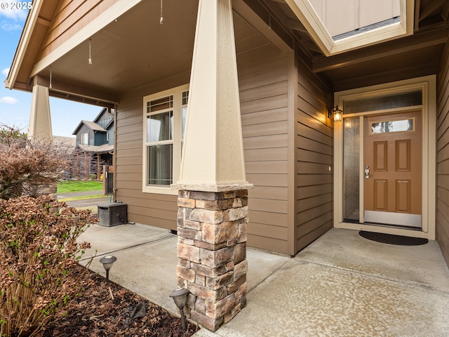 doorway to property with a porch and central air condition unit